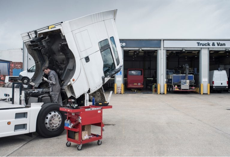 A man repairing a semi truck