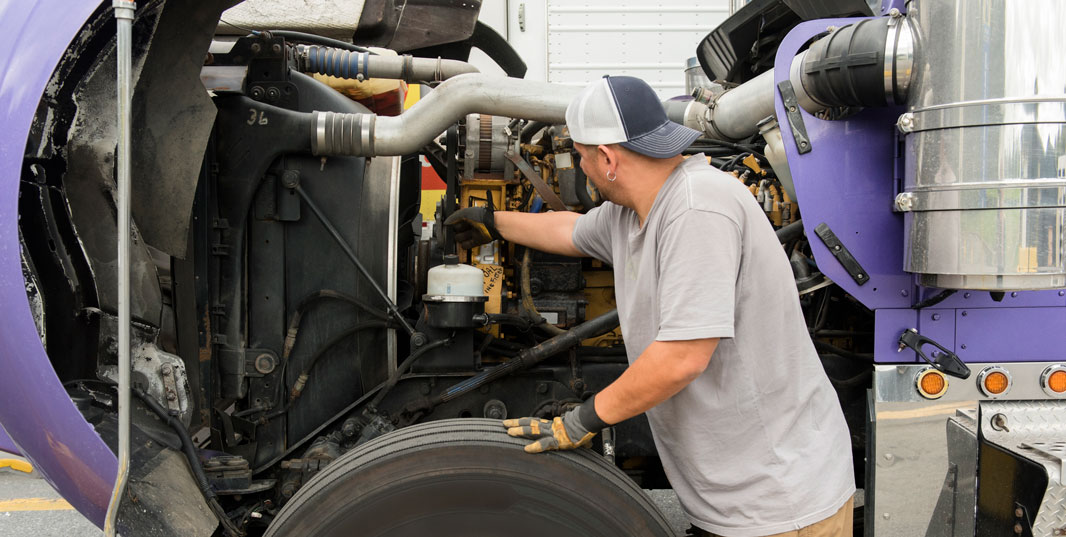 Truck driver cleaning semi-truck.